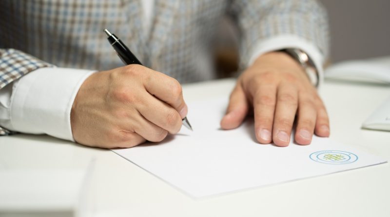 Mann mit Stift am Schreibtisch